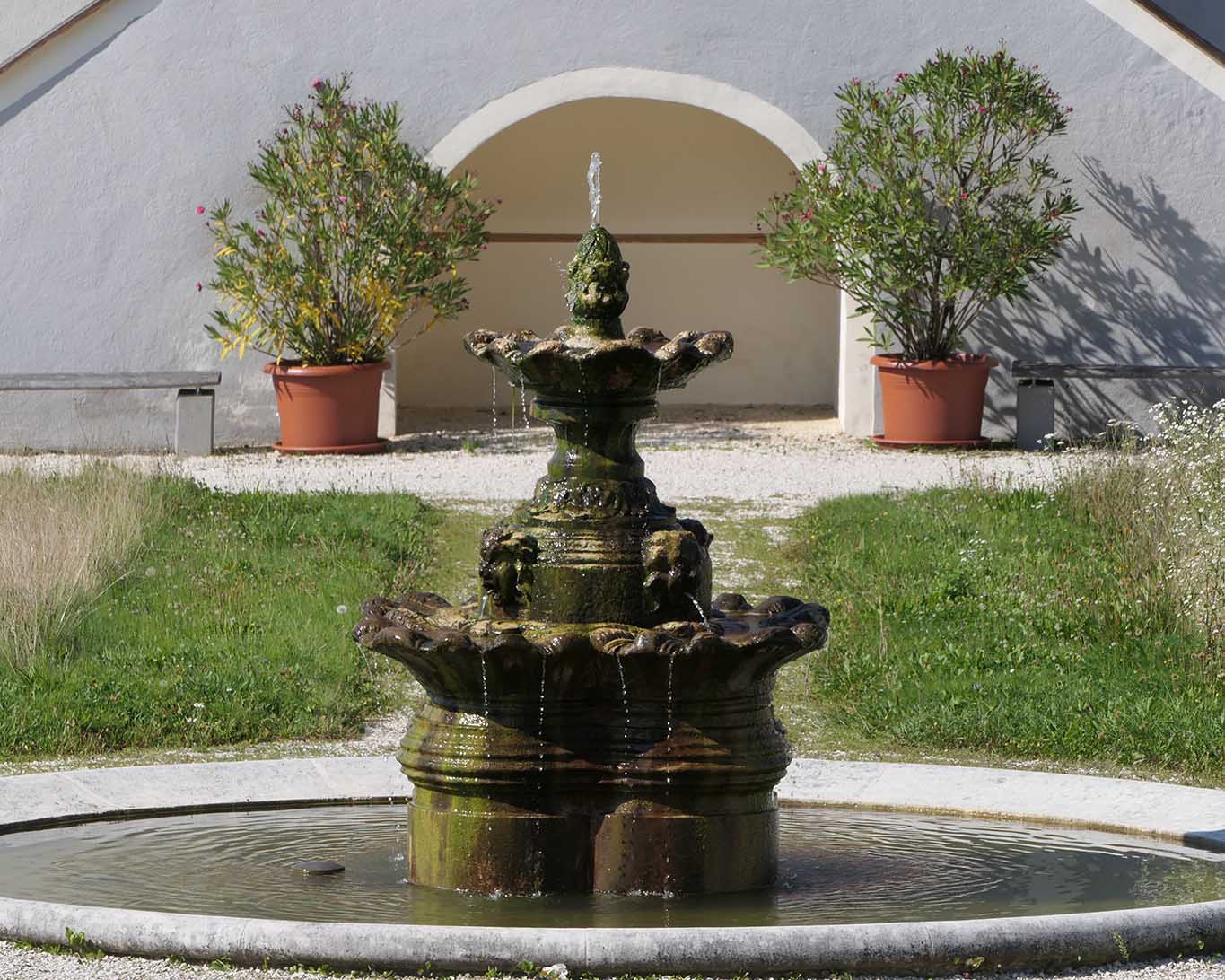 Plastiktöpfe, Unkraut, Moos und spärlich tropfende Rinnsale im Brunnen des verlotterten Barockgartens vom Stift St. Paul im Lavanttal.