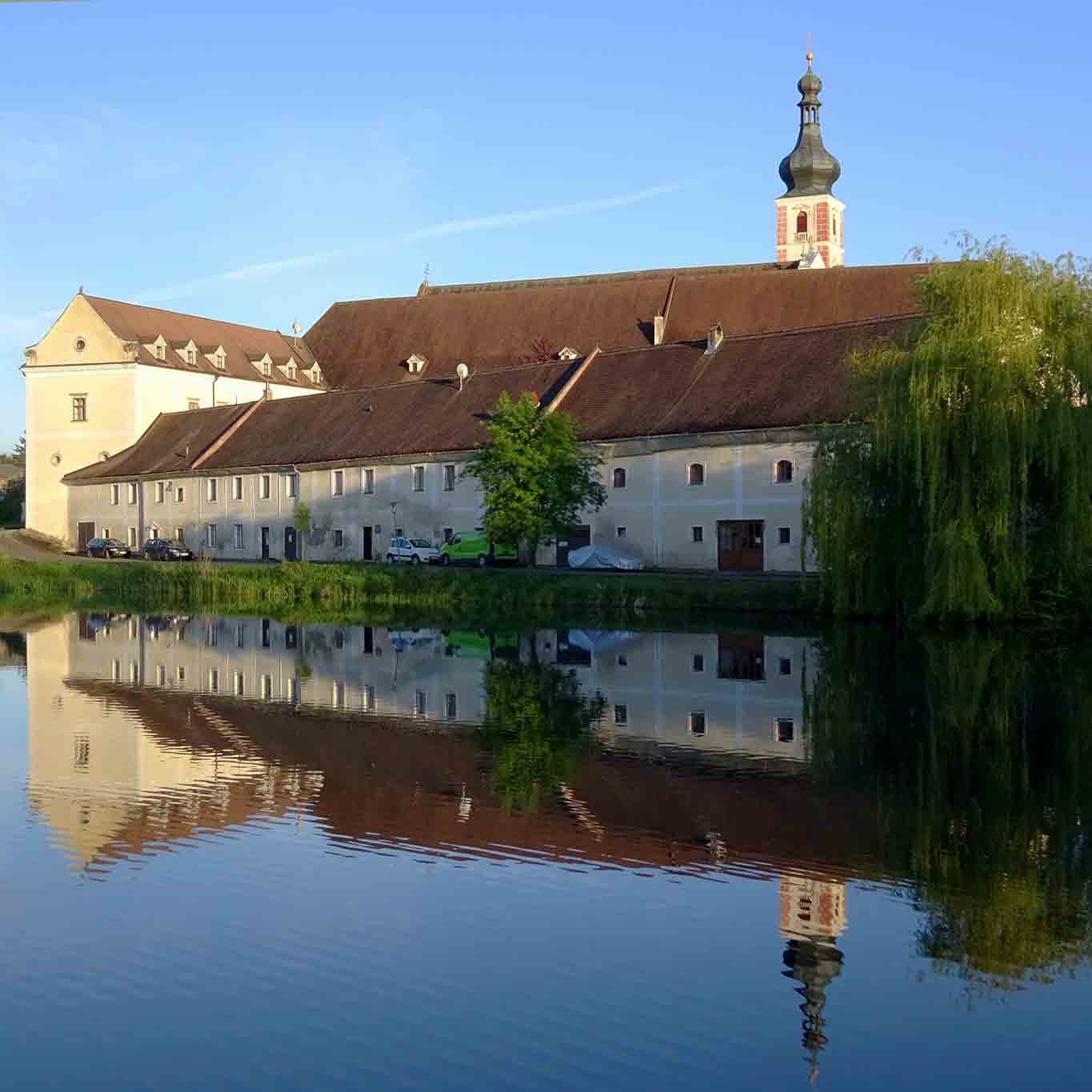 Stift Geras spiegelt sich im Wasser am Morgen eines Frühsommertages.