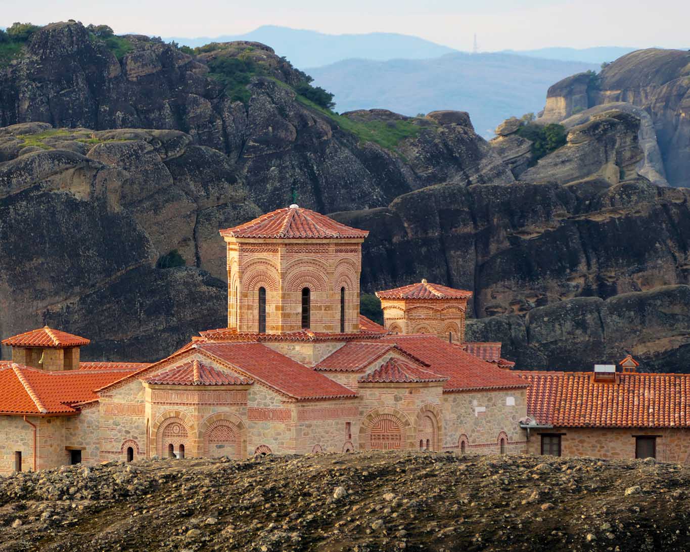 Im Morgenlicht über der Felsenlandschaft das Meteora-Kloster Agia Triada über Kalamphaka.