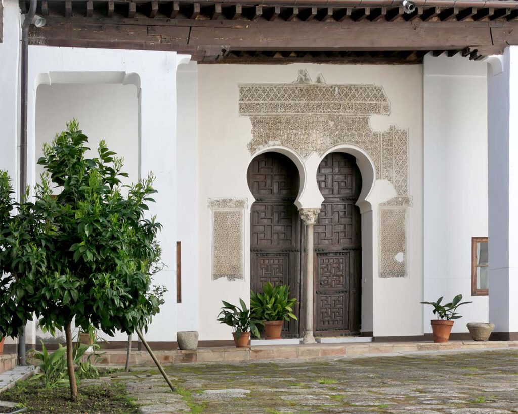 Die runden Türbögen am Eingang zum Kapitelsaal im El claustro del Naranjo sind Zeugnisse maurischer Baukunst.convento santa clara la real toledo orangenbaum kahl mauretanisches tor