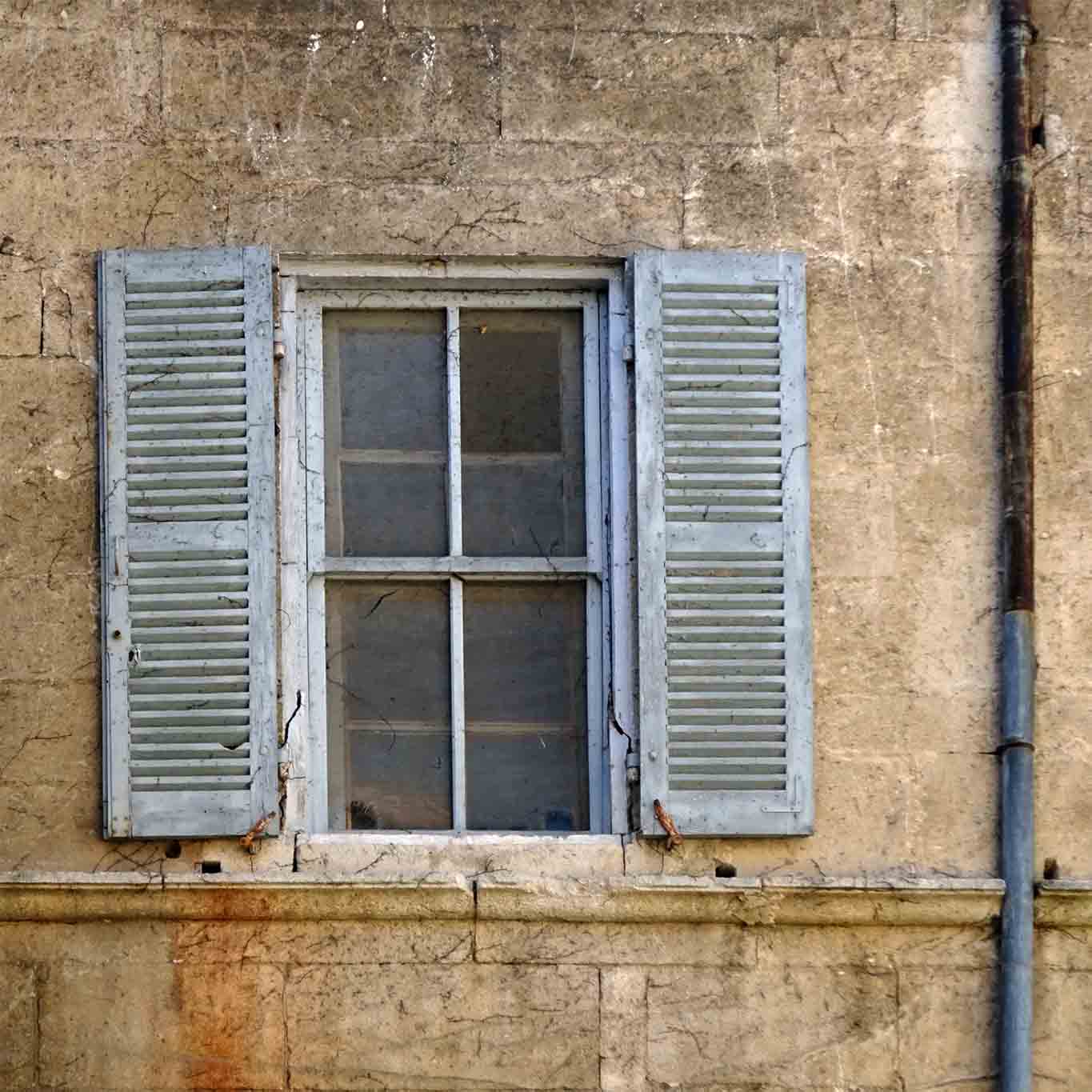 Alte Fensterläden mit bröckelnder Farbe am Gebäude des Cloitre Saint-Paul de Mausole.