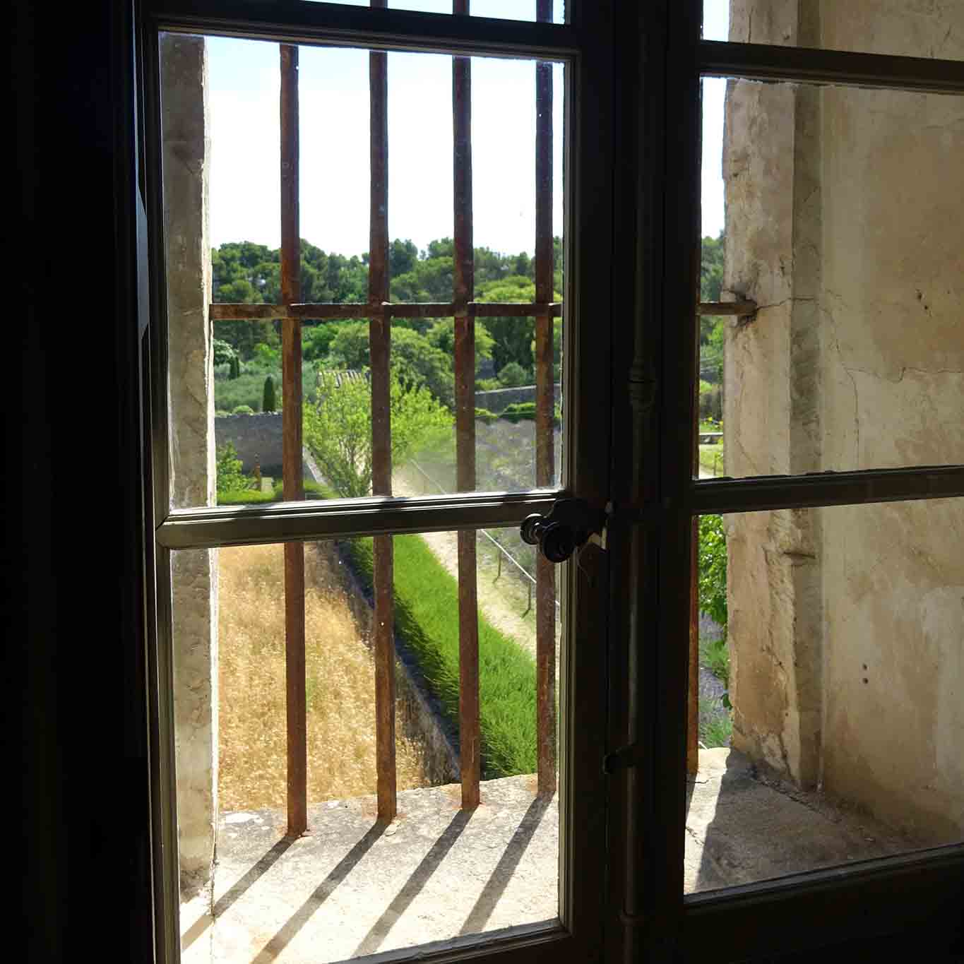 Vergittertes Fenster mit Gartenblick in den Klostergarten des Cloitre Saint-Paul de Mausole, aus dem vanGogh gesehen haben soll.