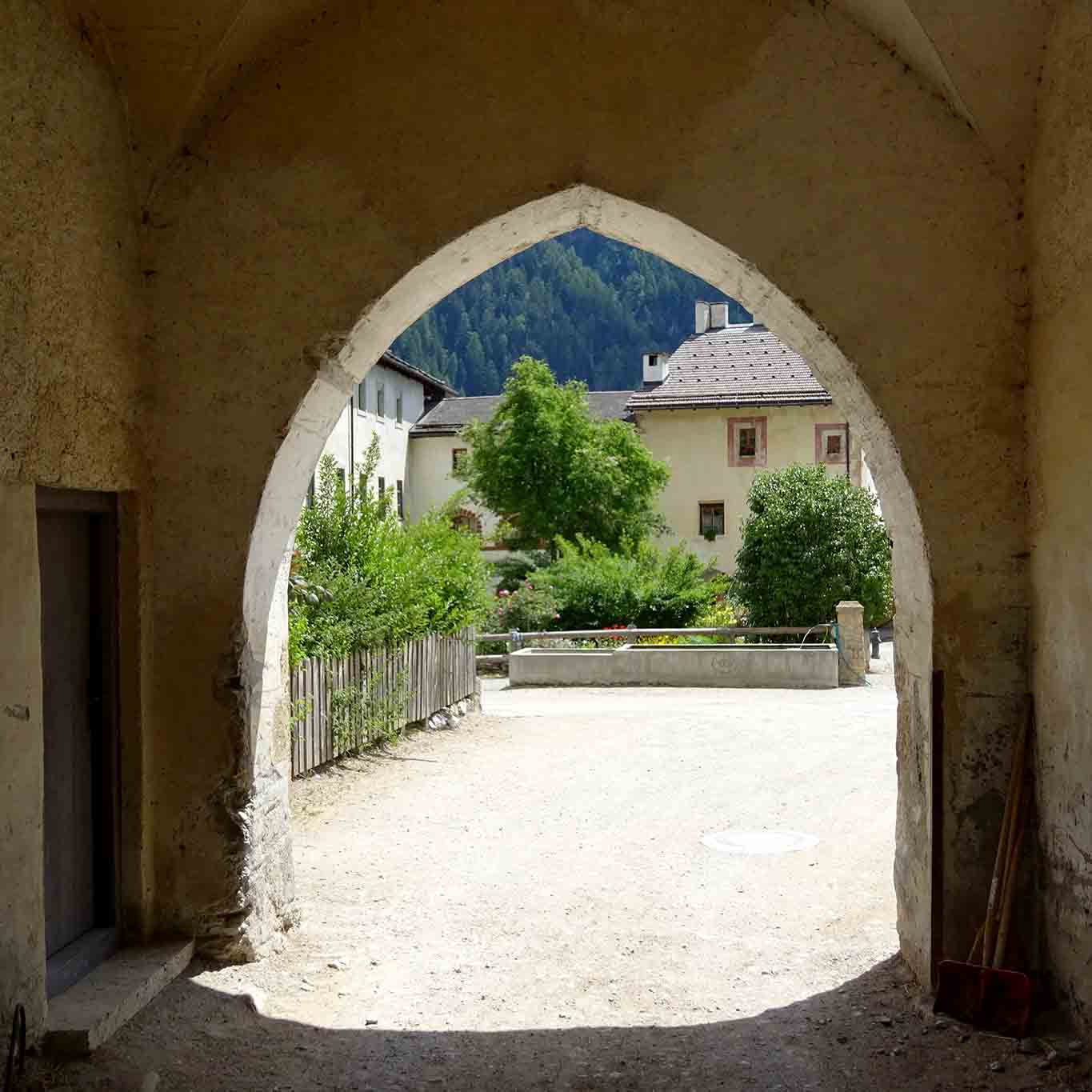 Vom Wald her betritt man das Kloster durch ein gotisches Portal. kloster muestair klostertor zur landwirtschaft