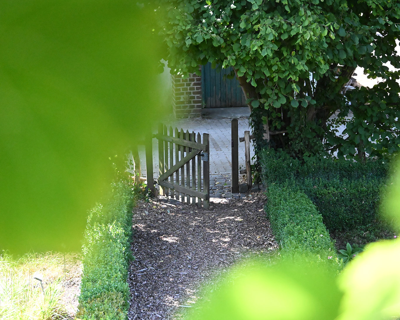 Das hölzerne Gartentor vom Kräutergarten des Klosters Knechtsteden schwingt immer wieder auf.