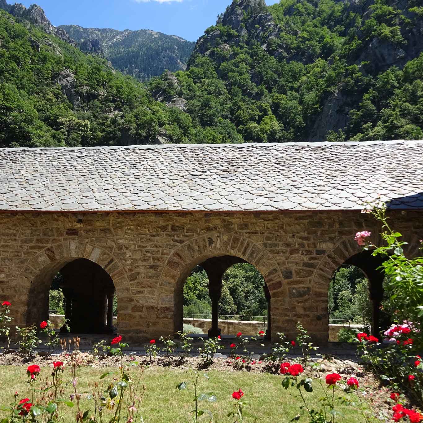 Der Rosengarten ist von den Gebäuden umrandet und von den hohen Bergen umstanden.